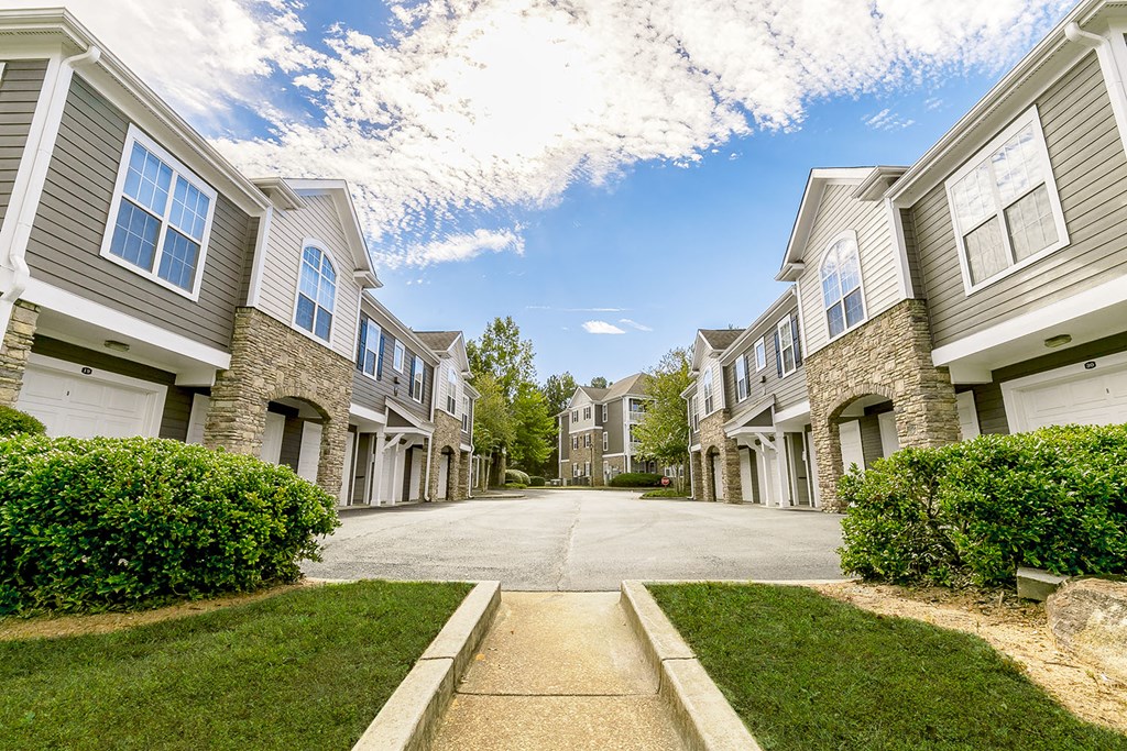 a view of an empty street between two apartment buildings