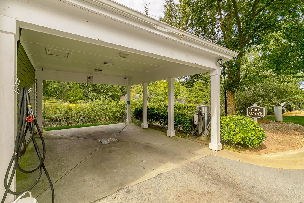 a gas station with a white roof and a driveway