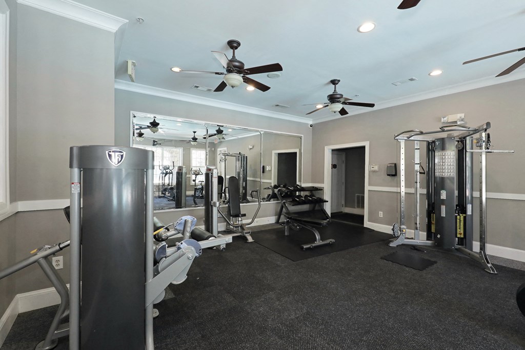 a gym with weights machines and ceiling fans