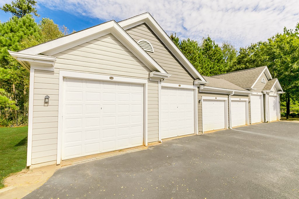 a row of three garages with white garage doors