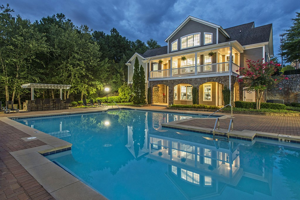 a large pool in front of a house at night
