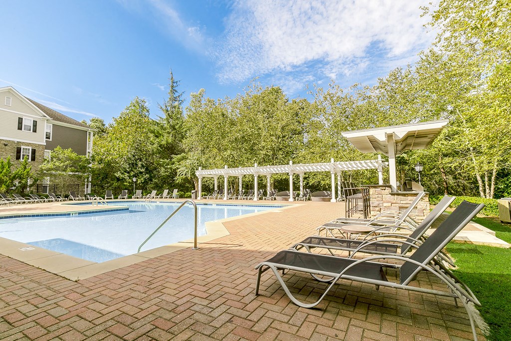 a swimming pool with lounge chairs and a poolside shade