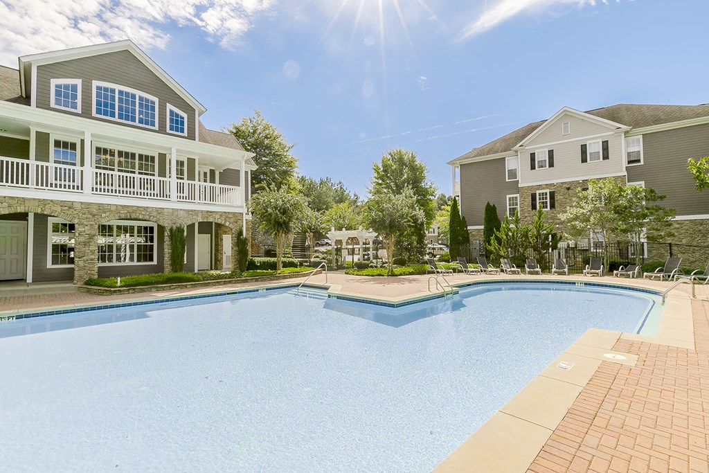a large swimming pool with houses in the background