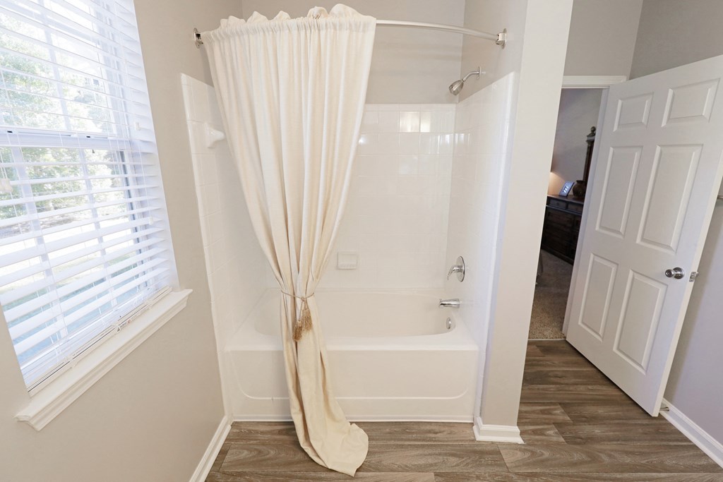 a bathroom with a shower curtain and a tub