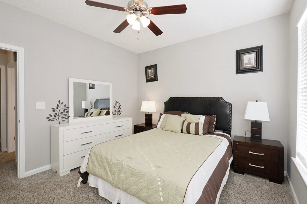 a bedroom with a large bed and a ceiling fan