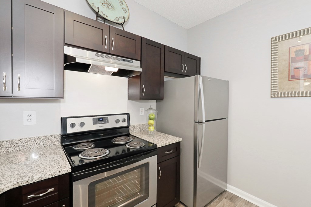 a kitchen with stainless steel appliances and granite counter tops and a refrigerator