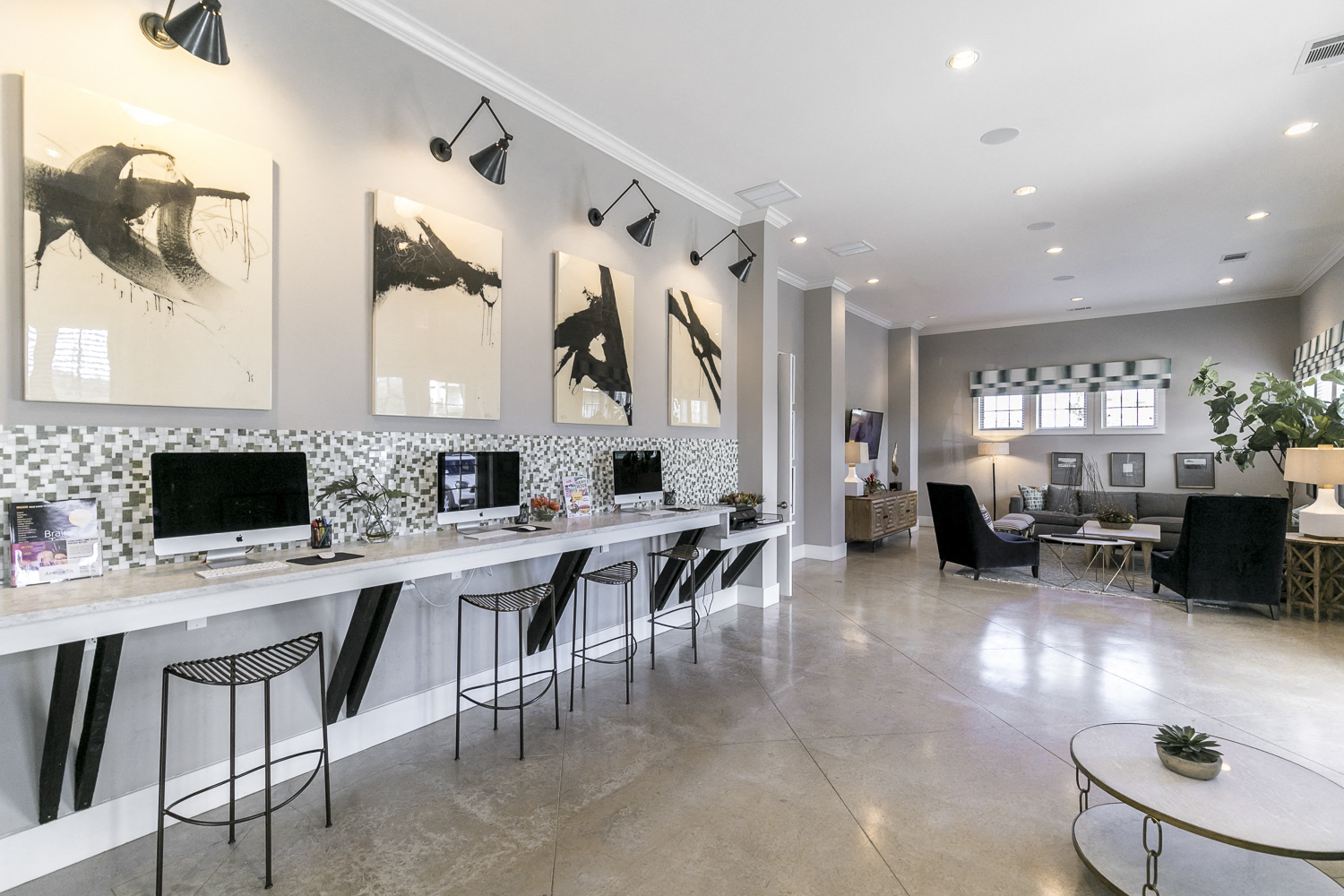 a living room with a long bar with chairs and computers
