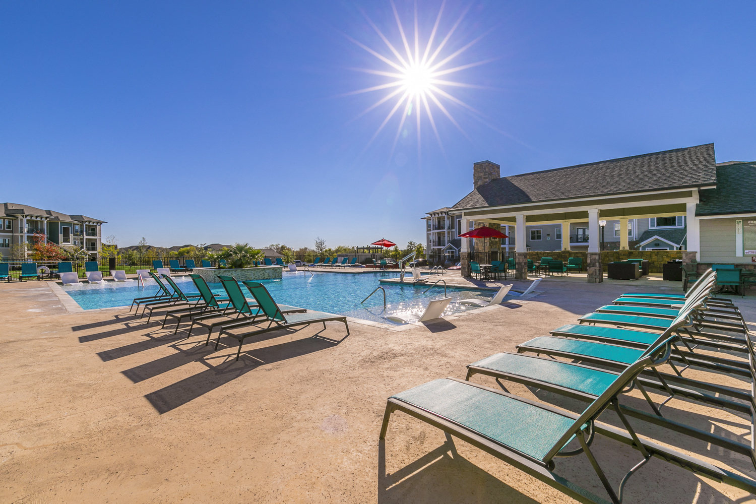 our resort style swimming pool is next to our building with lounge chairs
