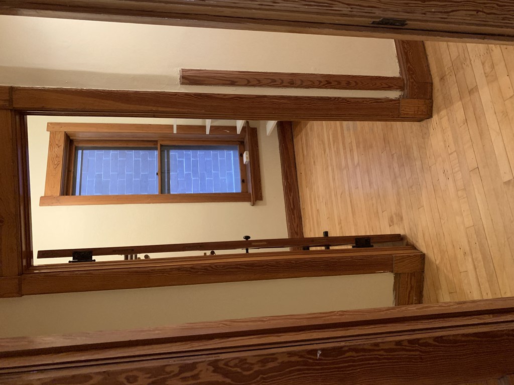 an empty room with a window and a wooden floor