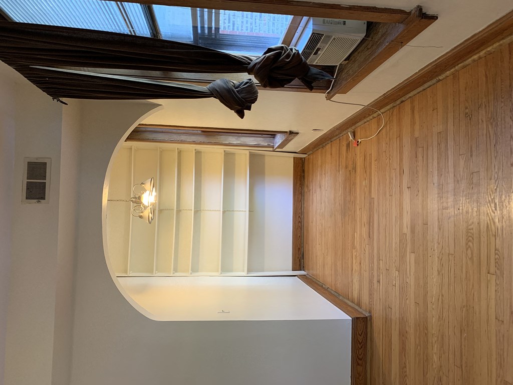 an empty room with a wood floor and shelves in it