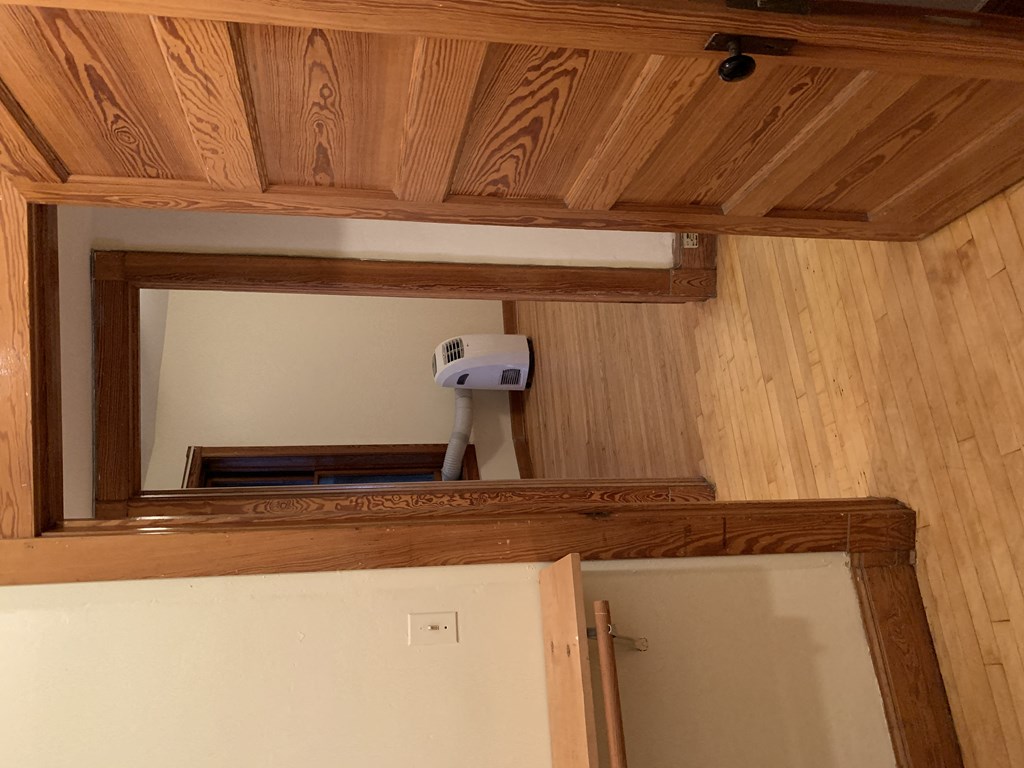 a room with a wooden door open to a bathroom and a washing machine
