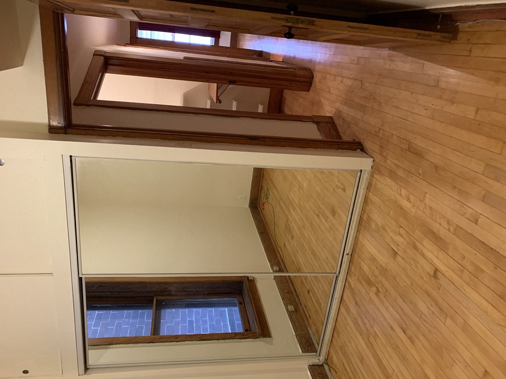 a room with a mirror on the wall and a wooden floor