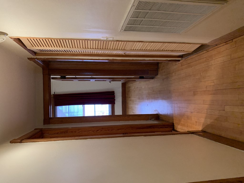a hallway with wood floors and a window and a closet