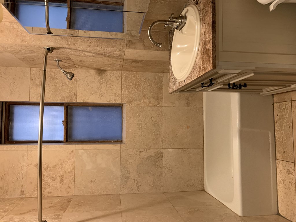 a bathroom with a shower and a sink and a bath tub