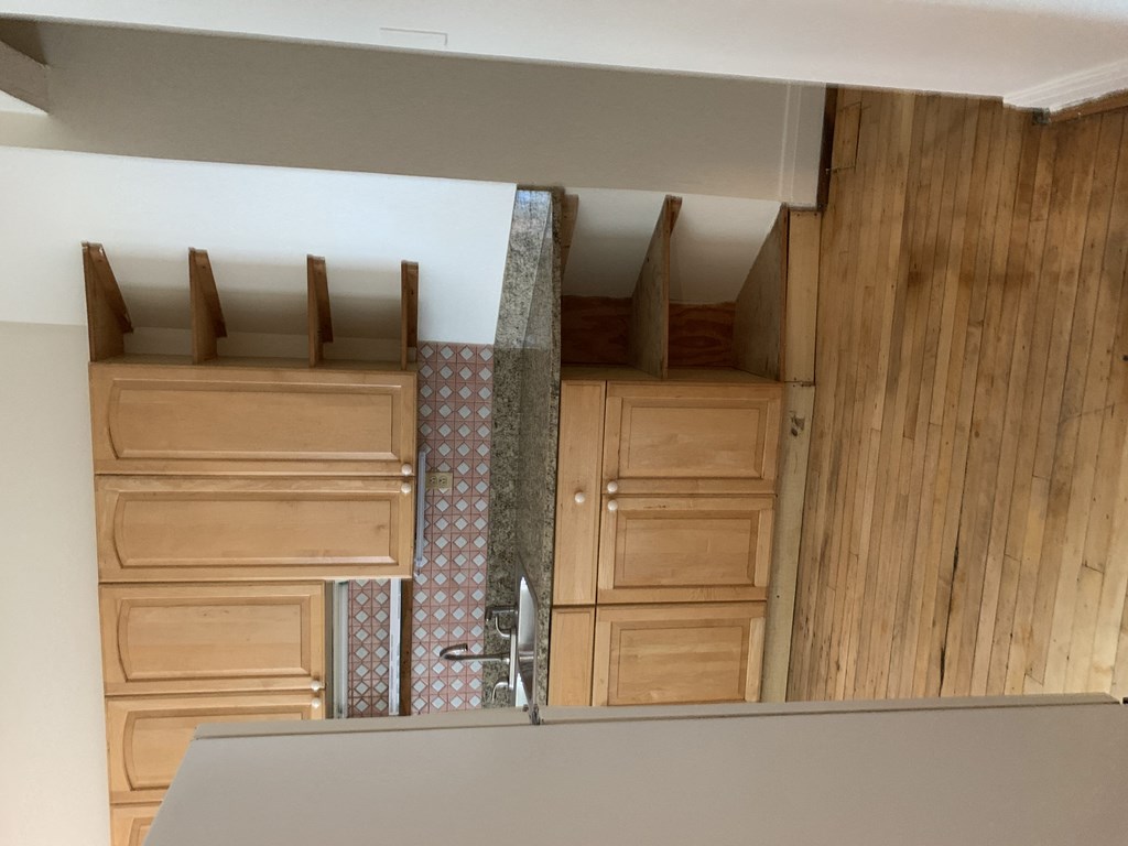 a small kitchen with wooden cabinets and a counter top and a sink