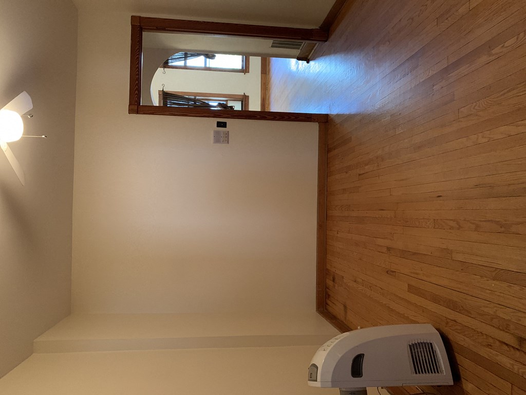 an empty living room with wood floors and a heater