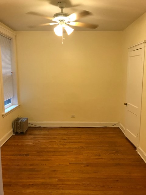 a empty room with a ceiling fan and a window