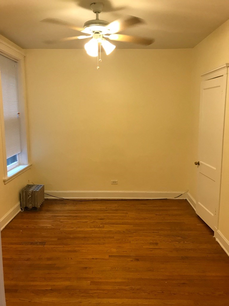 a empty room with a ceiling fan and a window