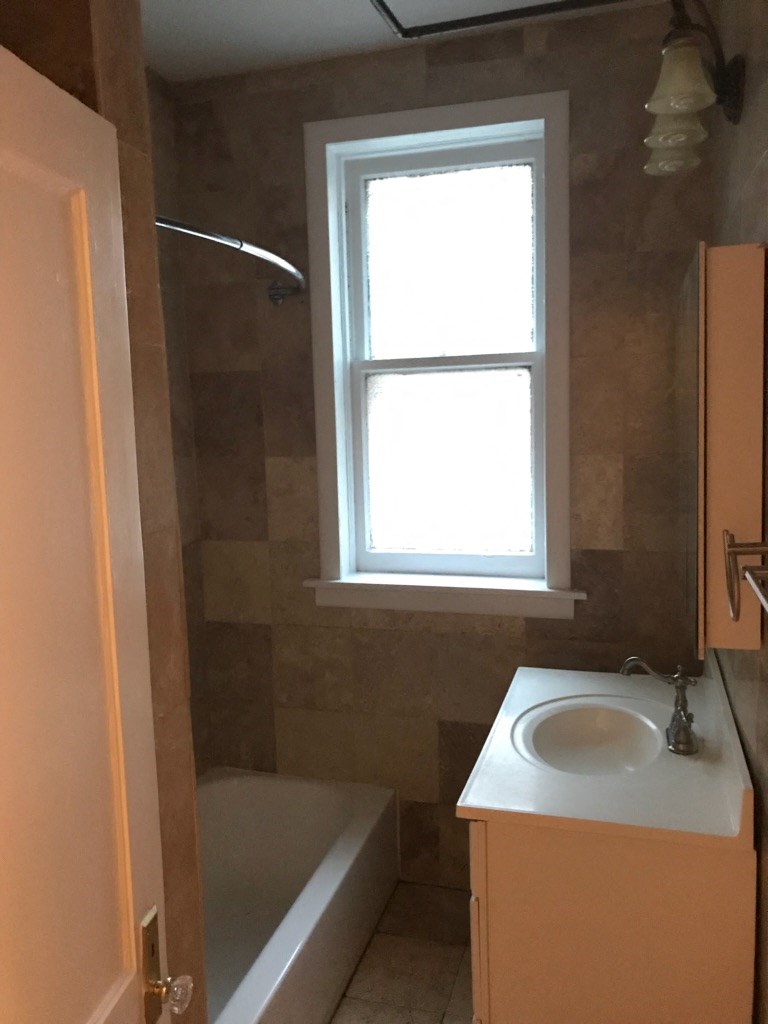 a bathroom with a sink and a tub and a window