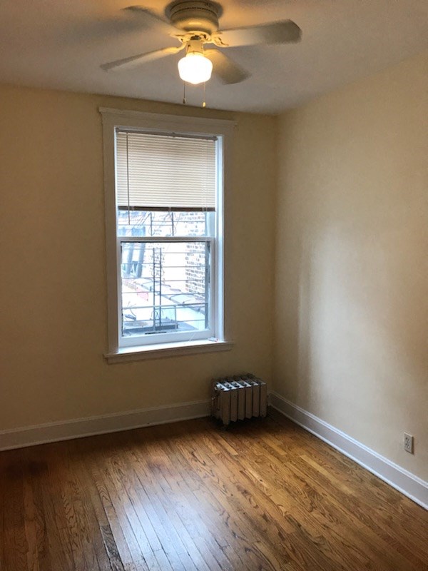 an empty room with a ceiling fan and a window