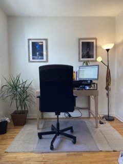 a desk with a computer and a chair in a room