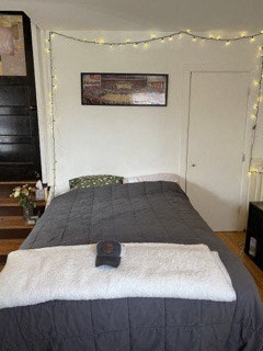 a bedroom with a bed with a black comforter