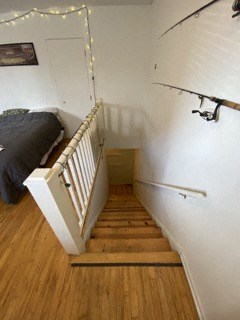 the stairs to a bedroom with a bed