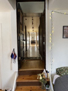 a hallway with a view of a room and a bed