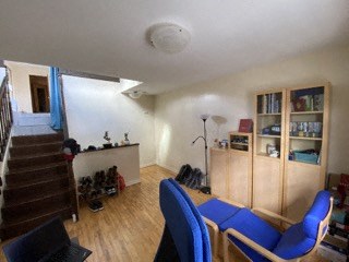 a living room with blue furniture and a staircase