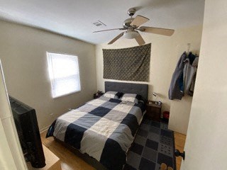 a bedroom with a checkered bed and a ceiling fan