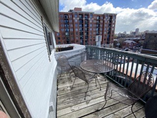 a balcony with a table and chairs on it