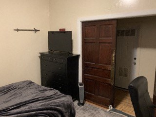 a bedroom with a bed and a dresser and a door