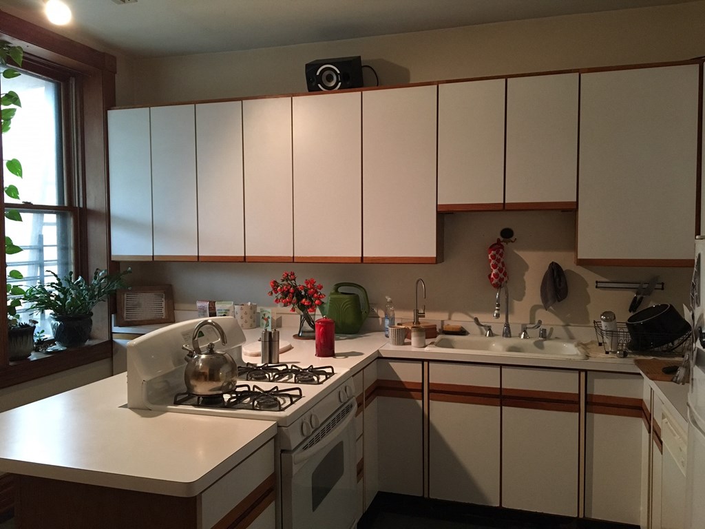 a kitchen with white cabinets and a stove and a sink