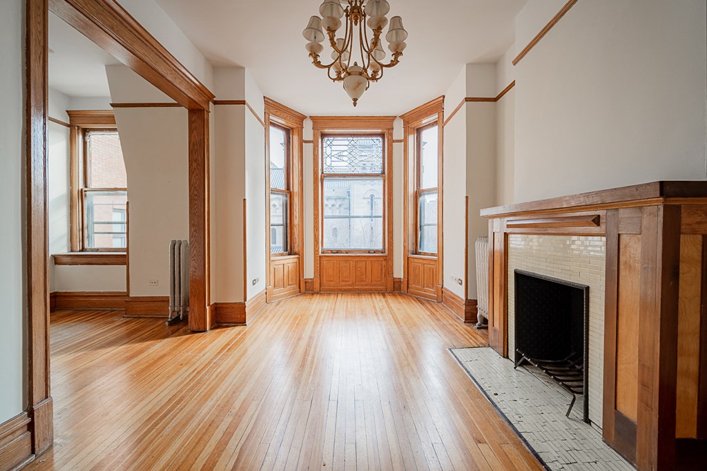 an empty living room with wood floors and a fireplace