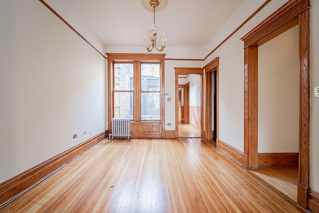 an empty living room with wood floors and a window