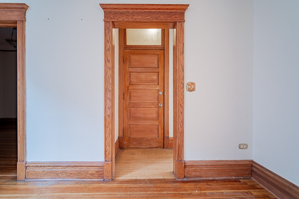 an empty room with a wooden door and a wooden floor