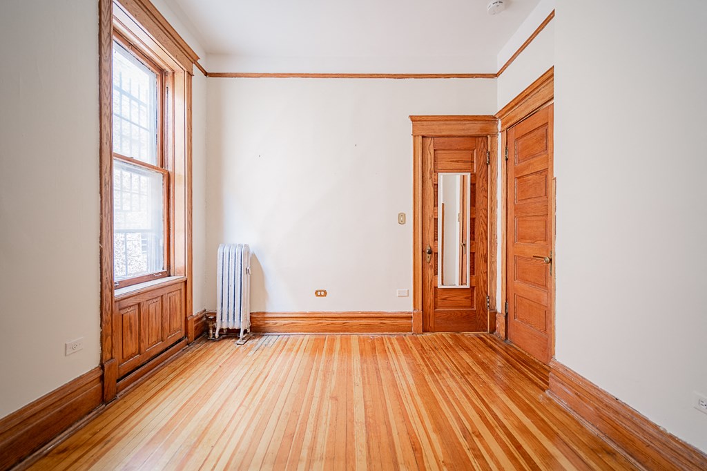 an empty room with wood floors and a door and window