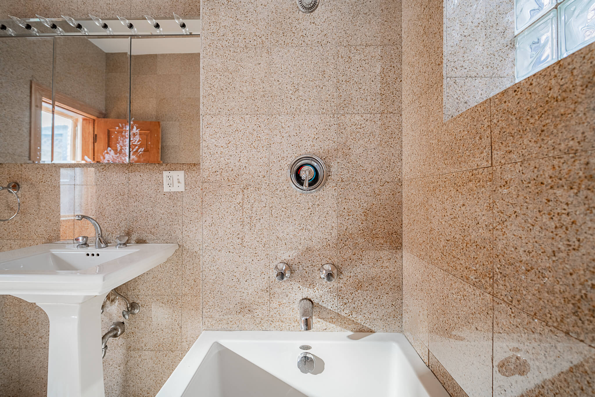 a bathroom with a tub and a sink and a mirror