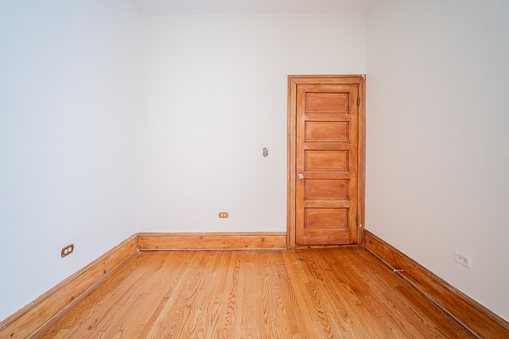 a empty room with wooden floors and a wooden door