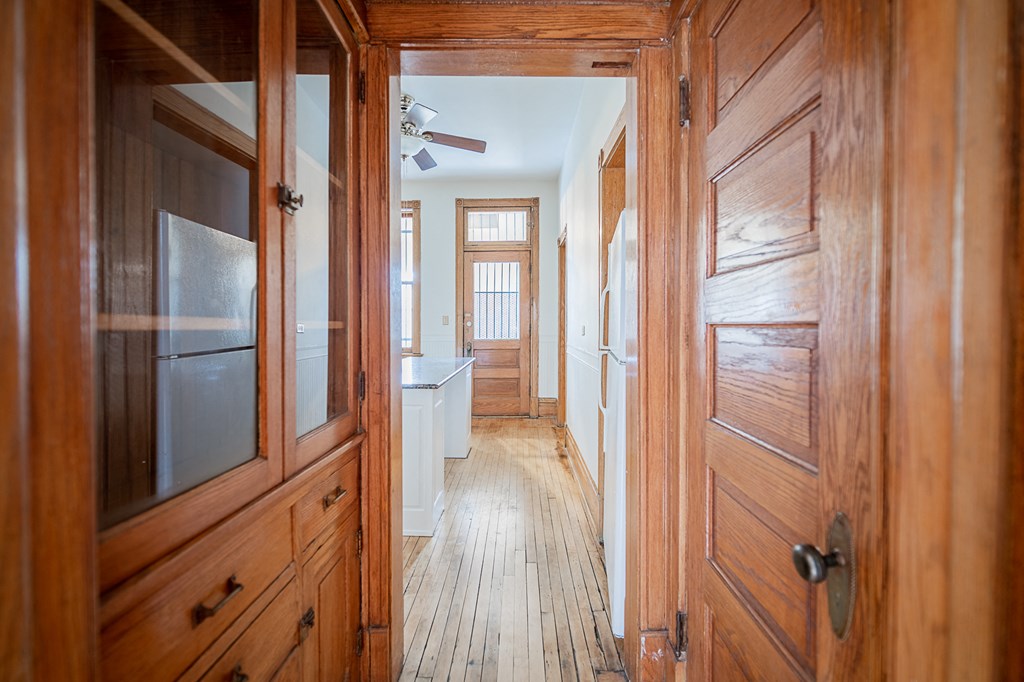 the hallway of a home with wood floors and wooden doors
