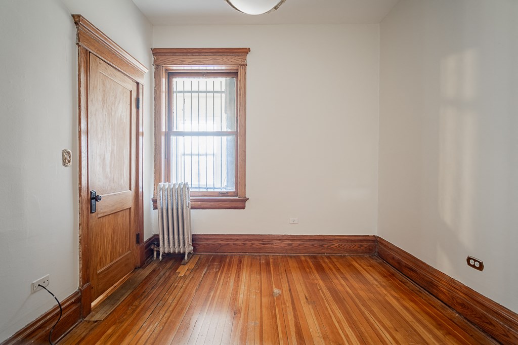 a room with wood floors and a window and a door