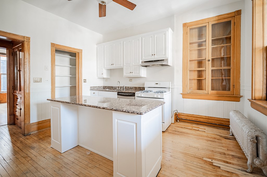 a kitchen with white cabinets and a counter top