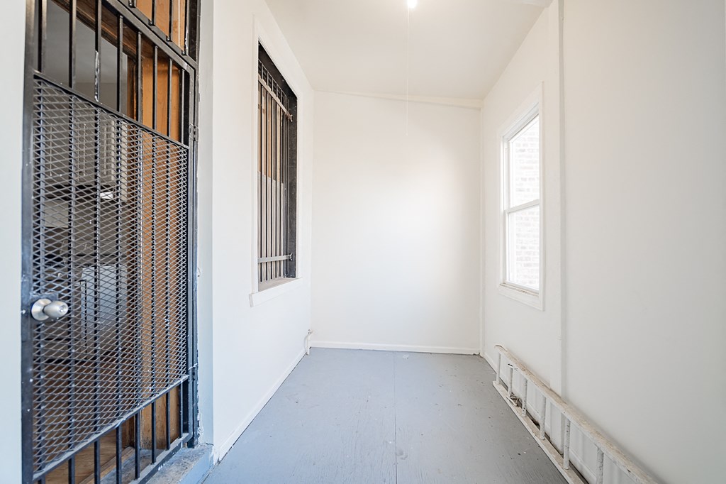 an empty room with a metal door and a window