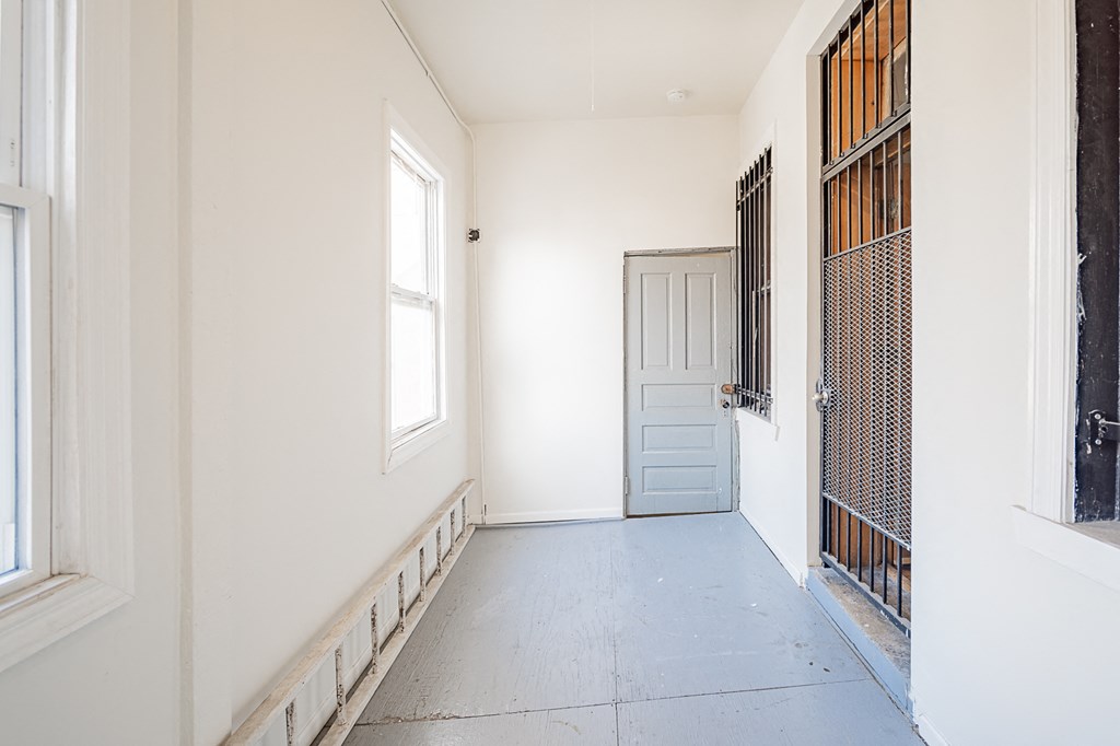 a white room with a white door and a window