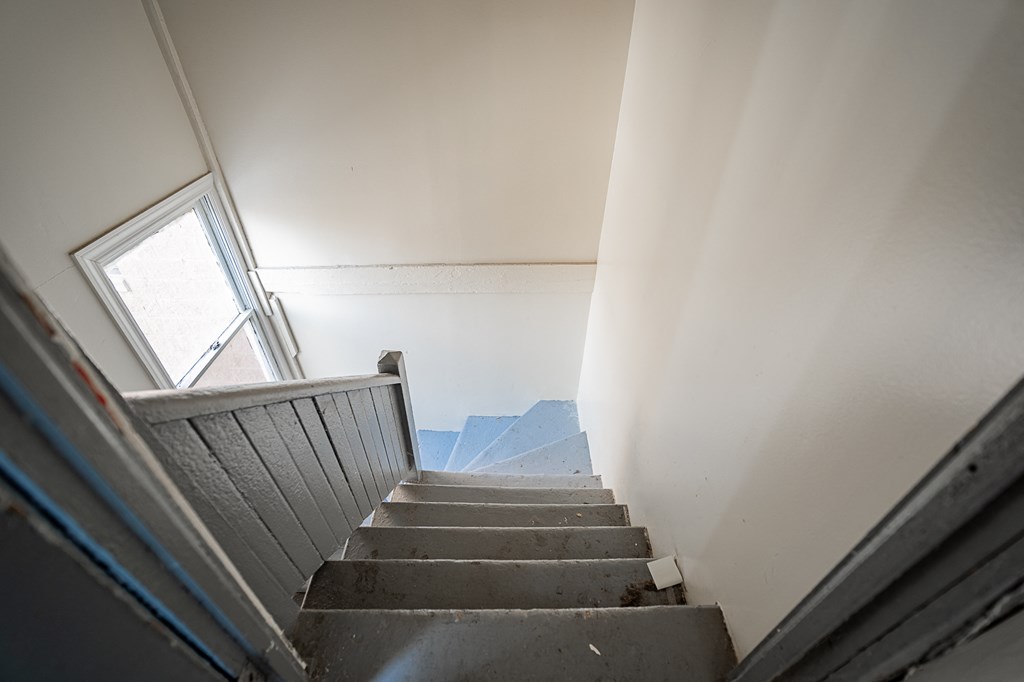 a set of stairs with a window and a door leading up them