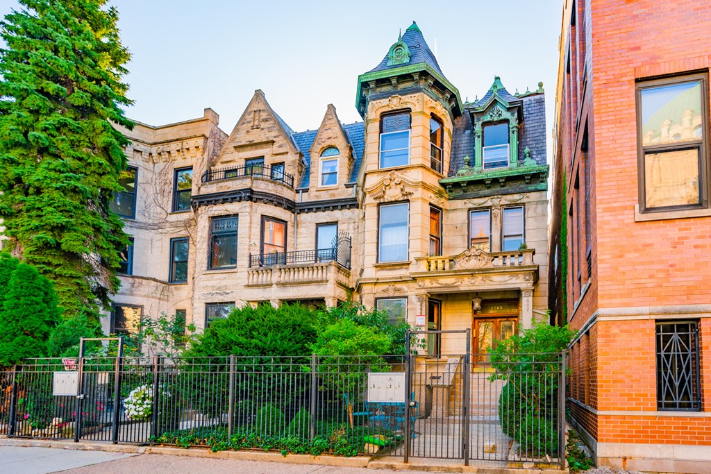 a mansion with a fence in front of it