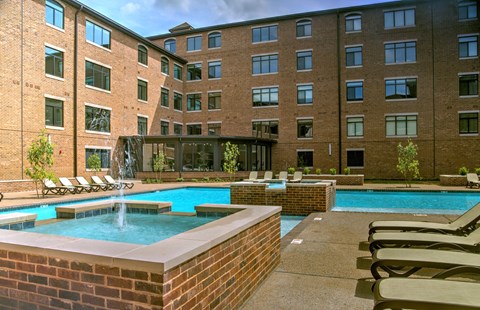 A pool with a fountain in the middle of it.