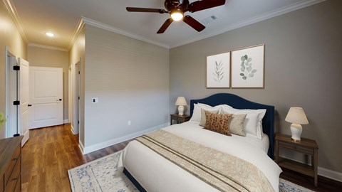 A bedroom with a large bed and a ceiling fan.