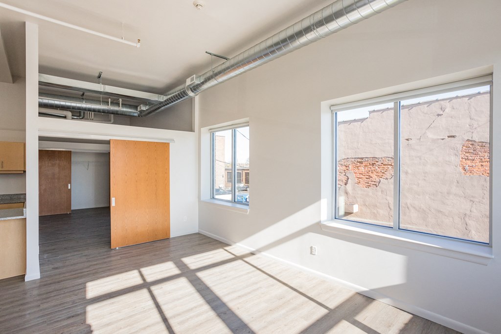 A room with a large window and a wooden floor.