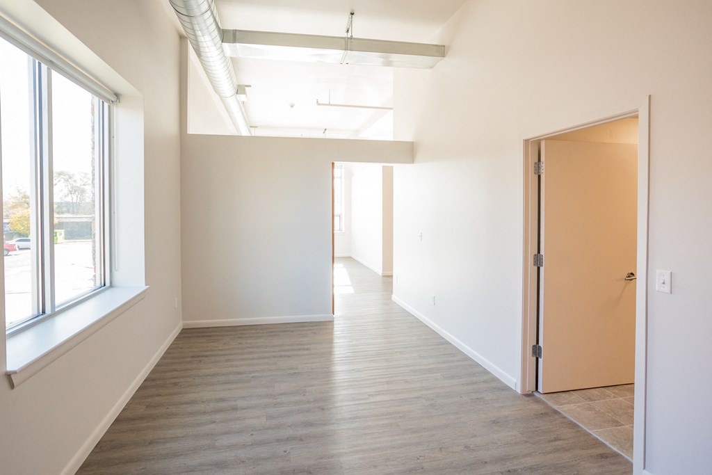 A room with a wooden floor and a door on the right side.